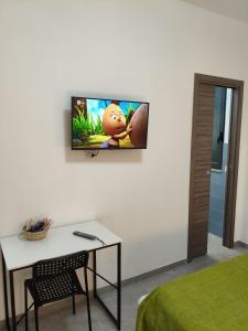 Zimmer mit einem Wand-TV und einem Tisch in der Unterkunft Affittacamere Domus Roseto in Roseto Capo Spulico + 9 Fotos