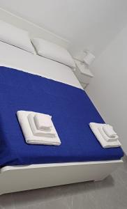 ein Bett mit blauen Laken und weißen Handtüchern darauf in der Unterkunft Affittacamere Domus Roseto in Roseto Capo Spulico