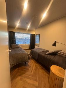 a bedroom with two beds and a large window at Apartment Alakorkalo in Rovaniemi