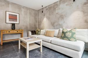 un soggiorno con un divano e un tavolo di Stone Cottage ad Arrowtown Altre 13 foto