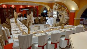 uma mesa longa numa sala com mesas e cadeiras brancas em Hôtel & Spa La Villa em Sainte-Maxime