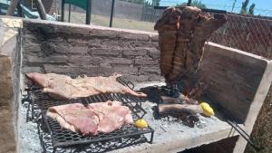 due pezzi di carne che cuociono su una griglia di Complejo La Cabañita a San Rafael