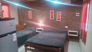 una camera da letto con due letti e un muro di mattoni di Complejo La Cabañita a San Rafael