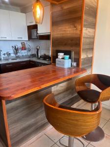 a kitchen with a wooden counter and a chair at Depto playa herradura in Coquimbo