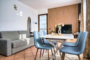 Una sala de estar con una mesa y sillas azules. en Belloro, en Zanica