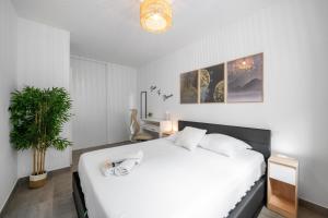 ein Schlafzimmer mit einem weißen Bett und einer Topfpflanze in der Unterkunft Modern Luxury - Sea View over Èze Village in Èze + 39 Fotos