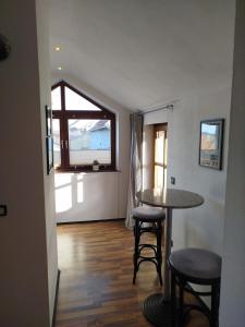 a room with a table and stools and a window at Altstadt Appartement Luka in Roding +7 photos