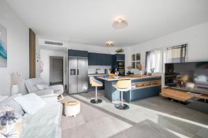 ein Wohnzimmer mit einer weißen Couch und einer Küche in der Unterkunft Modern Luxury - Sea View over Èze Village in Èze