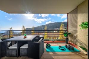 einen Balkon mit einem Tisch und Bergblick in der Unterkunft Modern Luxury - Sea View over Èze Village in Èze
