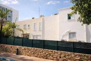 una recinzione di fronte a una casa bianca di Luxury point a Giv‘atayim