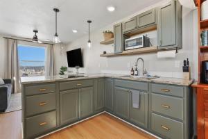a kitchen with green cabinets and a large window at Caldwell Cliff Swallow Guest House in Caldwell