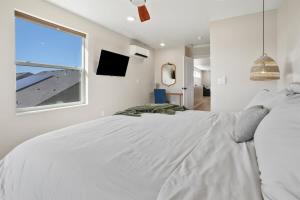 a white bedroom with a large bed and a window at Caldwell Cliff Swallow Guest House in Caldwell