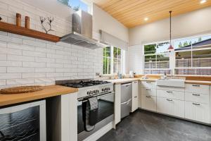 a kitchen with white appliances and a wooden ceiling at Stone Cottage in Arrowtown