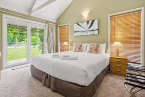 a bedroom with a large bed and a window at Arrow Junction Cottage in Arrowtown