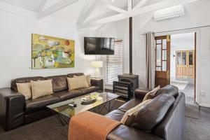 een woonkamer met een bank en een open haard bij Arrow Junction Cottage in Arrowtown