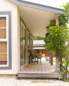 een veranda van een huis met een tafel en stoelen bij Arrow Junction Cottage in Arrowtown