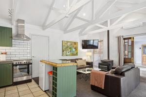 een keuken en een woonkamer met een bank bij Arrow Junction Cottage in Arrowtown