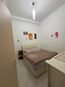 a bedroom with a bed in a white room at Lisi apartment in Tirana