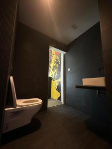 a bathroom with a white toilet and a window at Club Ébène Ouidah in Ouidah
