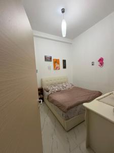 a small bedroom with a bed and a sink at Lisi apartment in Tirana