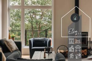 a living room with two chairs and a table and a window at Chalet Elva Nature & SPA in Sainte Béatrix