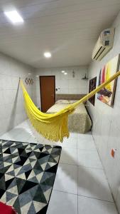 un'amaca gialla in una stanza con un letto di Kitnet 1 ambiente a Campina Grande