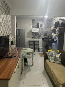una cucina e un soggiorno con un divano e un tavolo di Flat 23, Condomínio Manguezal a Porto De Galinhas
