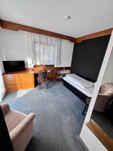 a hotel room with a bed and a desk and a chair at Bed & Breakfast Schäfer in Enzklösterle