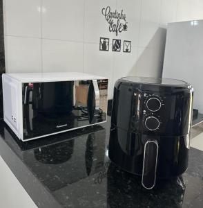 a microwave sitting on top of a kitchen counter at Cantinho Girassol na Serra da Canastra in São Roque de Minas