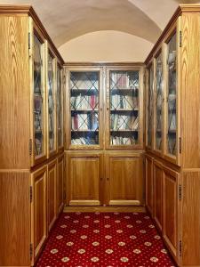 een lege keuken met houten kasten en een rood tapijt bij Oasi Francescana il Monastero in Vicovaro