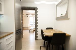 Una cocina y un comedor con mesa y sillas. en Apartment with Private Garden, en Liptovský Mikuláš