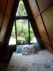 een bed in een kleine kamer met een raam bij Chalé Garças in Chapada dos Guimarães