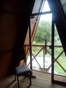 een stoel voor een raam bij Chalé Garças in Chapada dos Guimarães
