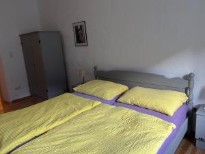 a bedroom with two beds with yellow sheets and a cabinet at Sonilife Ferienwohnung Obervellach in Obervellach