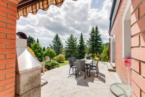 a patio with a table and chairs and a brick building at Vila Adalbert in Liberec