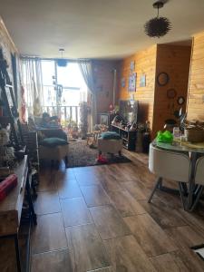 a living room with wooden walls and a large window at Departamento cómodo full equipado in Puerto Montt