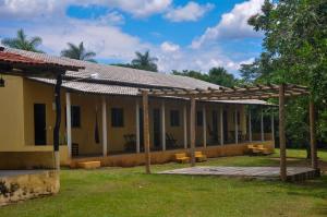 a building with a pergola in the yard at Pousada Diadorim Terra Ronca in Sao Domingos de Goias