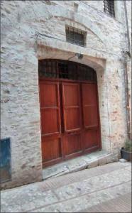 a large wooden door in a stone building at Casa "La Fonte" in Spoleto