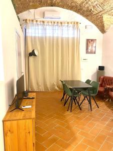 a dining room with a table and chairs and a television at Casa "La Fonte" in Spoleto