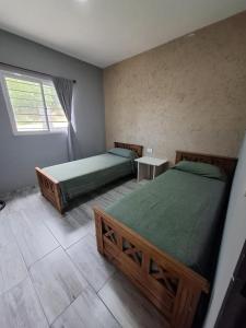 een slaapkamer met twee bedden en een raam bij Entre Sierras Cabañas in Tanti