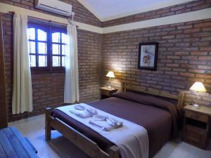a bedroom with a bed and a brick wall at Cabañas La Morada de Tanti in Tanti +21 photos