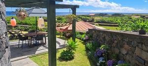 eine Terrasse mit Tisch, Stühlen und Sonnenschirm in der Unterkunft Casas de Brisa in Calheta