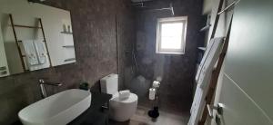 ein Bad mit einem weißen WC und einem Fenster in der Unterkunft Casas de Brisa in Calheta + 55 Fotos
