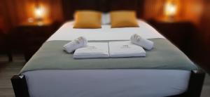 zwei Betten in einem Hotelzimmer mit Handtüchern darauf in der Unterkunft Casas de Brisa in Calheta