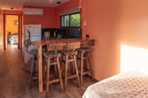 a kitchen with a bar with stools and a refrigerator at Container Los Lobos in Chapadmalal
