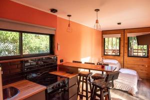 a kitchen with orange walls and a counter with stools at Container Los Lobos in Chapadmalal
