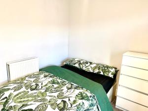 een kleine slaapkamer met een bed en een dressoir bij OA Housing - Spacious 2 Bedrooms in Spon End