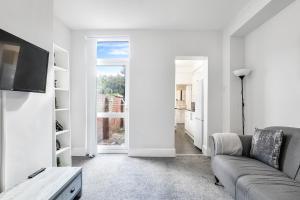 een woonkamer met een bank en een tv bij OA Housing - Spacious 2 Bedrooms in Spon End