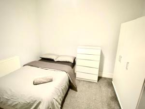een kleine slaapkamer met 2 bedden en een dressoir bij OA Housing - Spacious 2 Bedrooms in Spon End