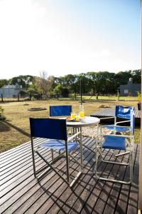 two chairs and a table on a deck at Container Los Lobos in Chapadmalal